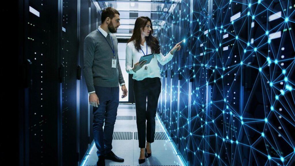 a man and woman standing in a server room